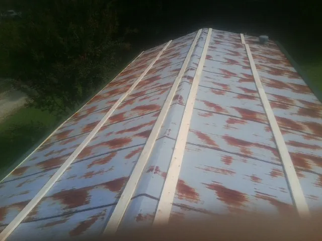 Rusted metal roof panels with new wood purlins before replacement — Storm Damage Roof Repair in Senecaville by Roofing Brothers