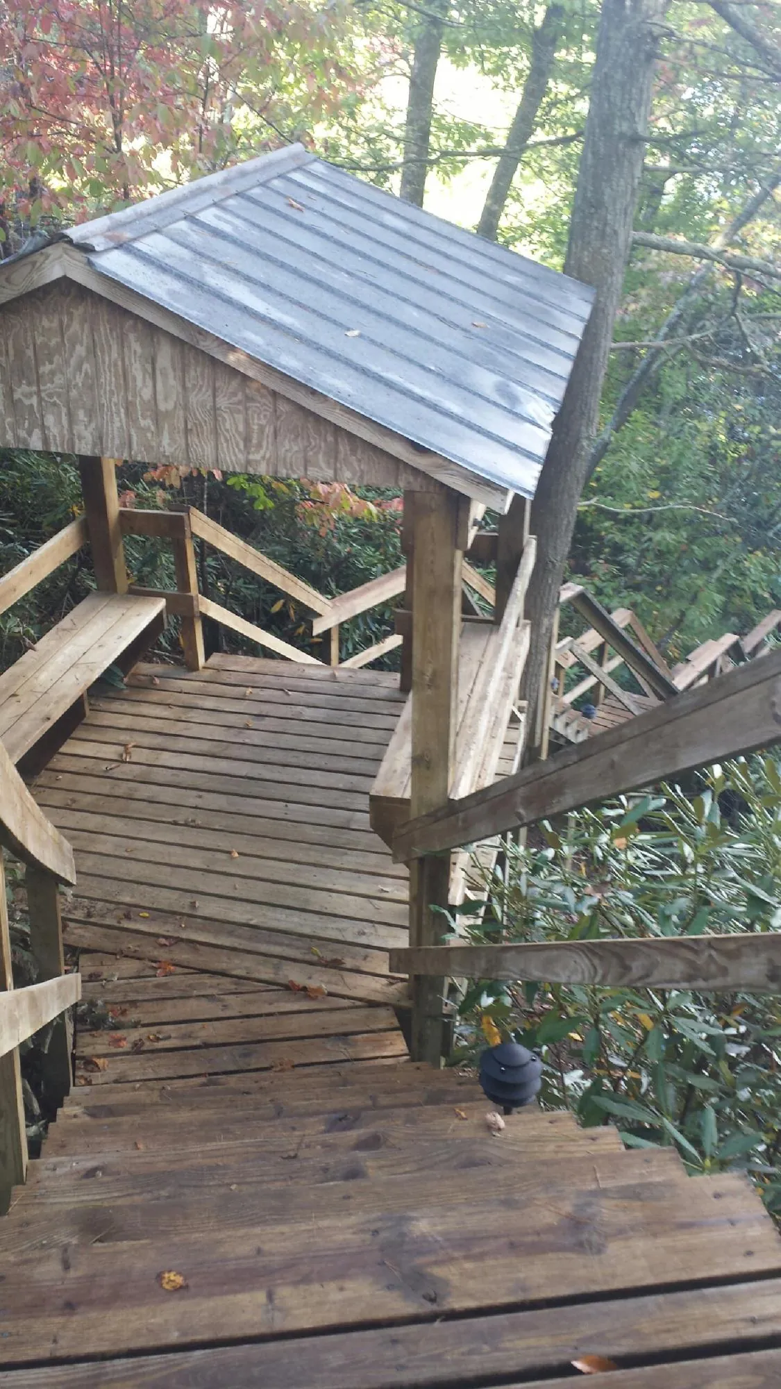 Metal roofed shelter over wooden steps on a wooded walkway — Skylight Repair & Installation work by our crew in Senecaville