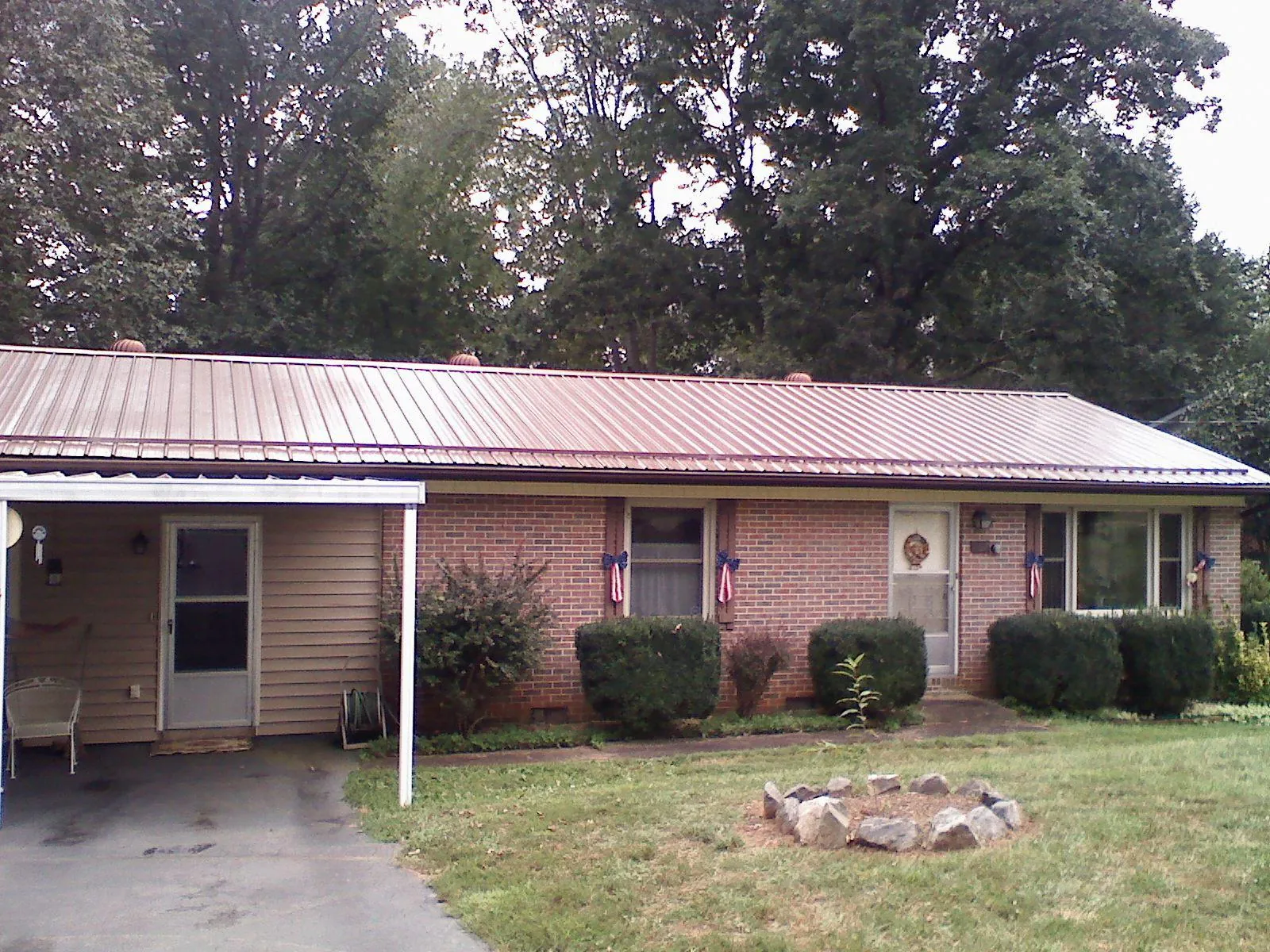 Bronze metal roof and carport on a brick ranch home — Roof Repair work by our crew in Senecaville